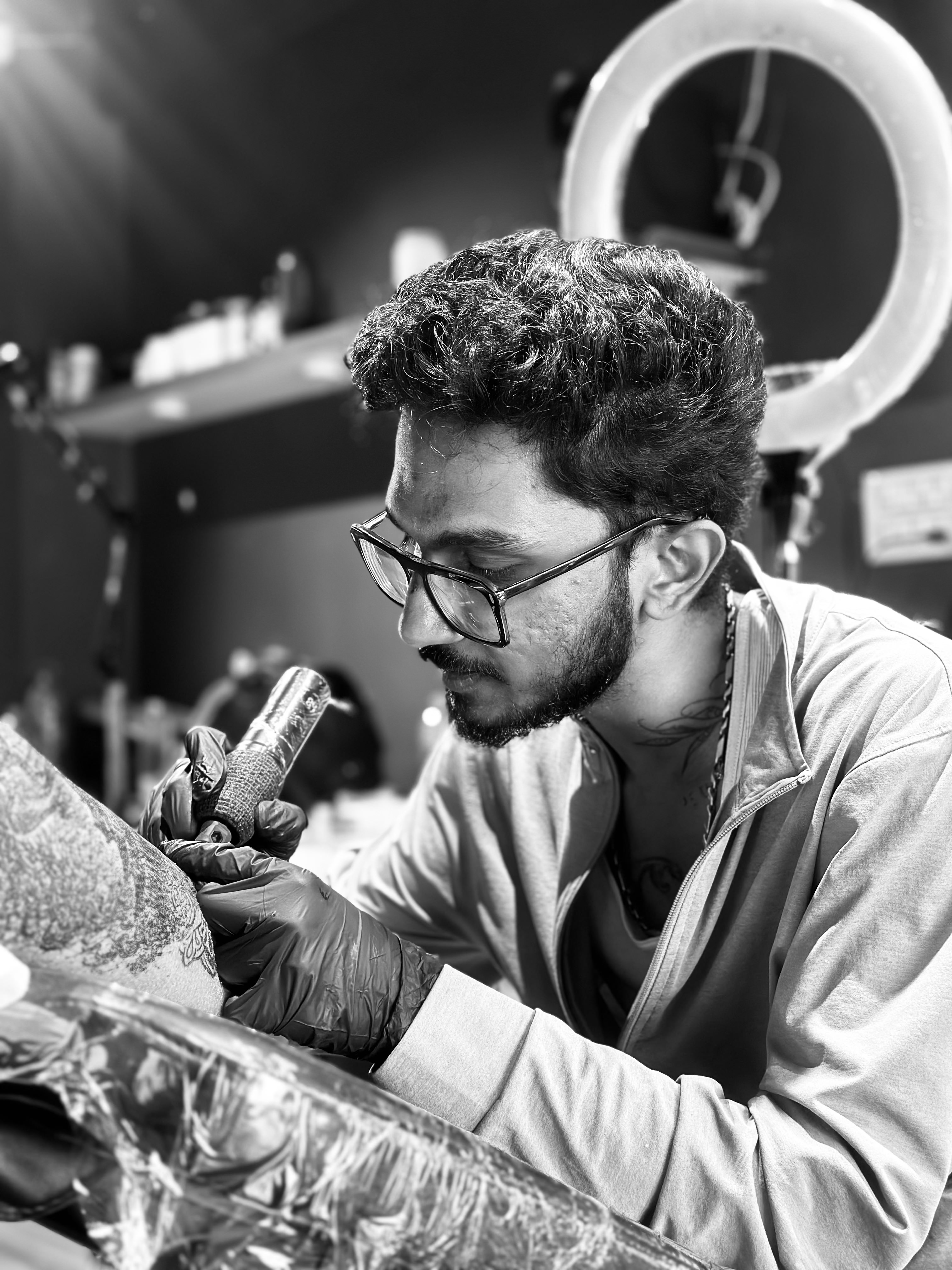 Portrait of Adam Droko tattooing a client