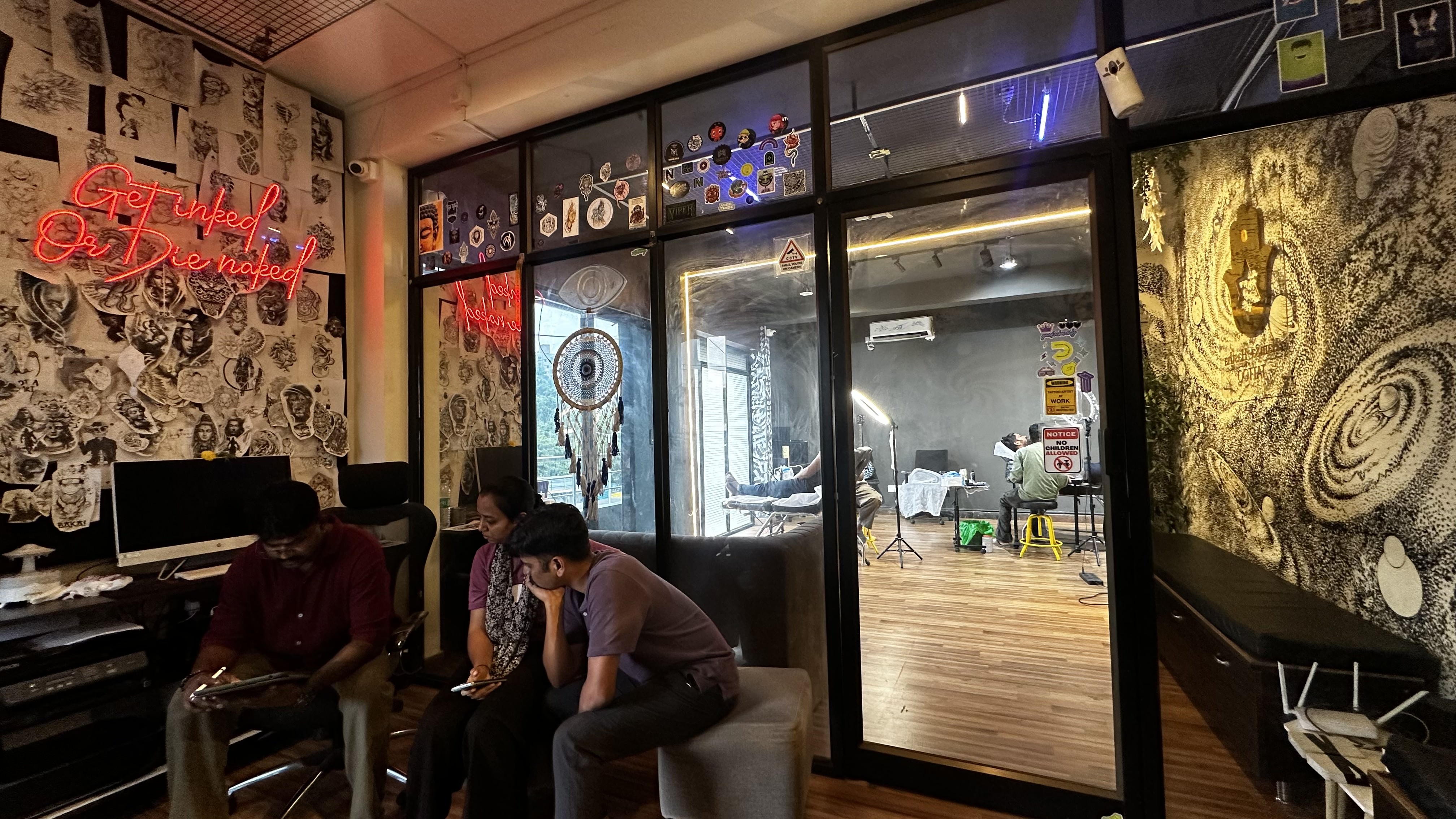 Reception and waiting area with Get Inked Or Die Naked neon and flash wall